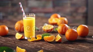 把橙子和果汁放在木制背景的玻璃杯里切碎。